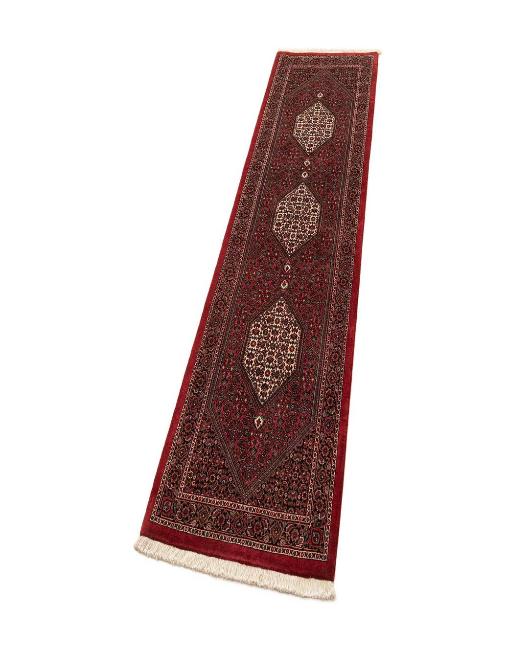 A handmade 8 ft red runner rug with a traditional medallion pattern and fringe, ideal for a hallway or kitchen.
