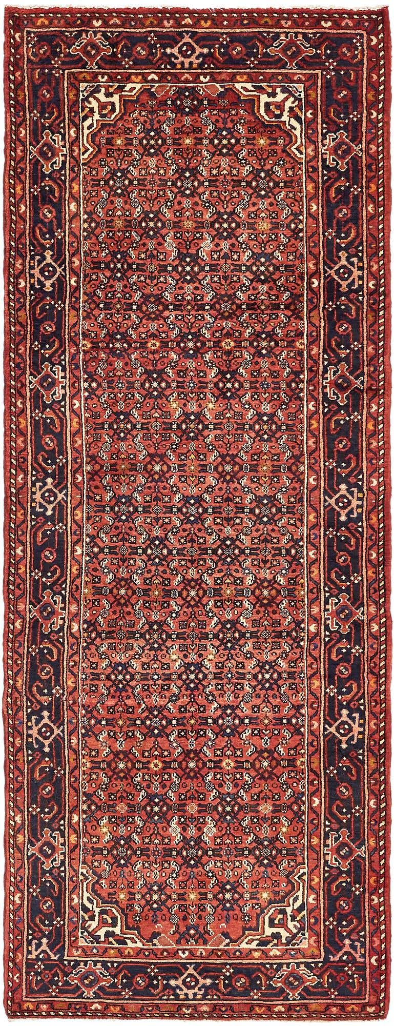 A 10 ft runner rug in traditional Persian tribal style, featuring intricate red and navy patterns, ideal for a hallway.