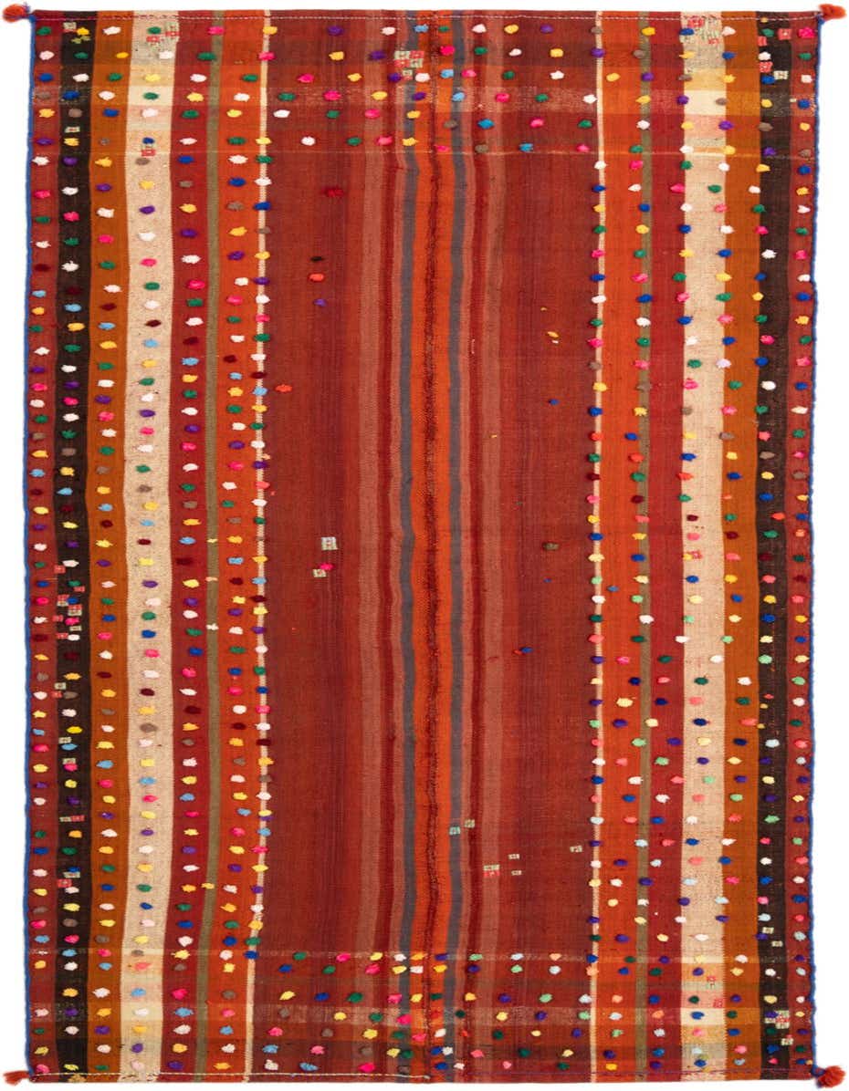 A handmade 8 ft runner rug with a Persian striped pattern in various reds, accented with colorful pom-poms.