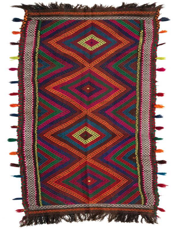 A vibrant 9 ft Kilim Fars runner rug with a tribal geometric pattern in reds, blues, greens, and oranges, featuring colorful tassels along the sides.
