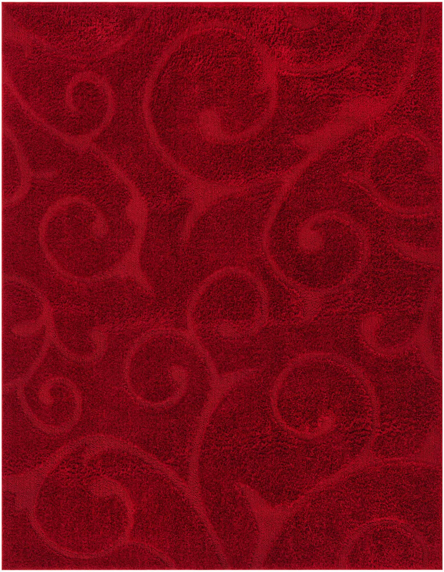 A close-up of a vibrant red shag rug featuring subtle, raised floral and scroll patterns, showcasing its plush texture.