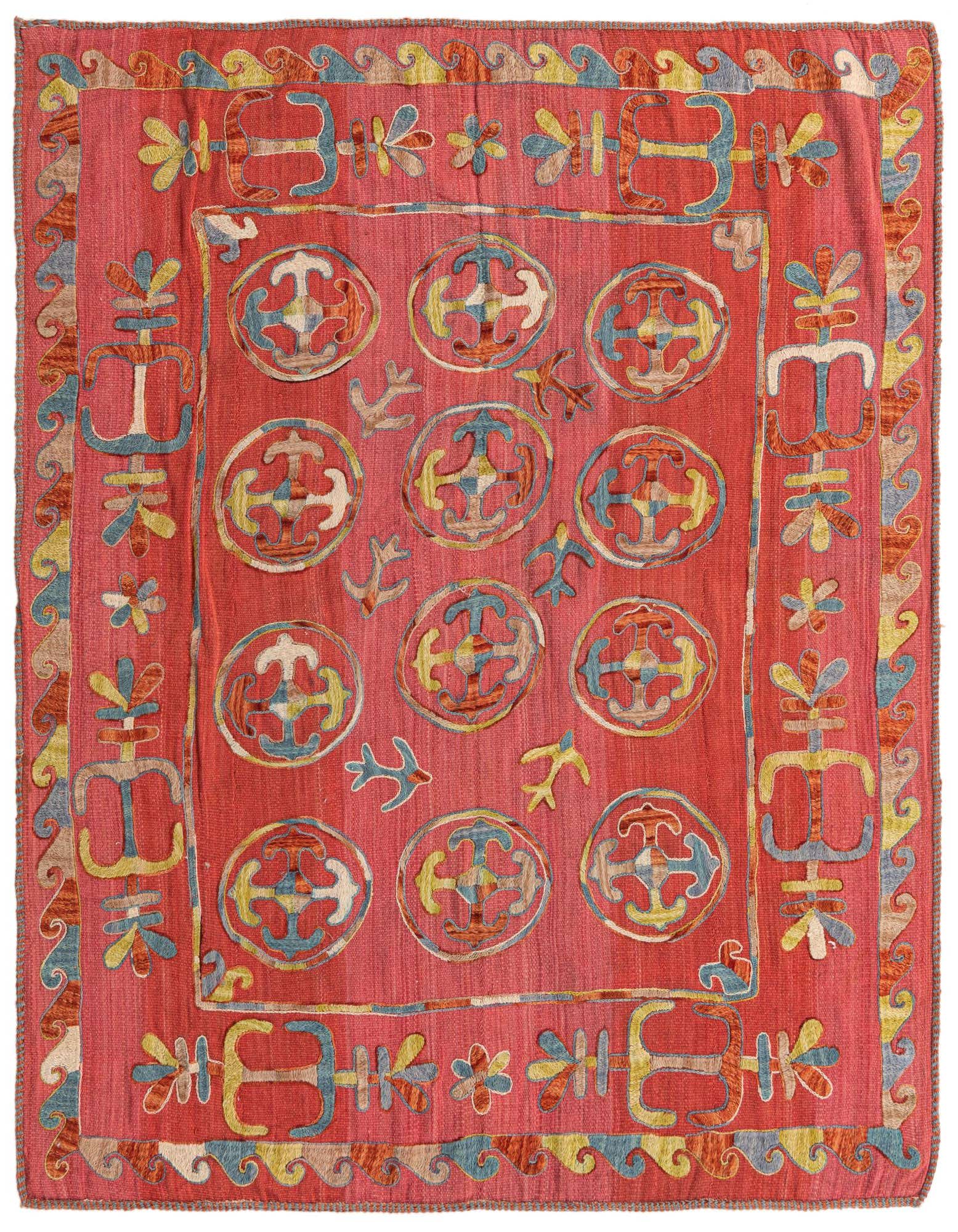 A 5x8 rectangular red Kilim Suzani rug with a tribal pattern of blue, yellow, and white circular motifs and border designs.