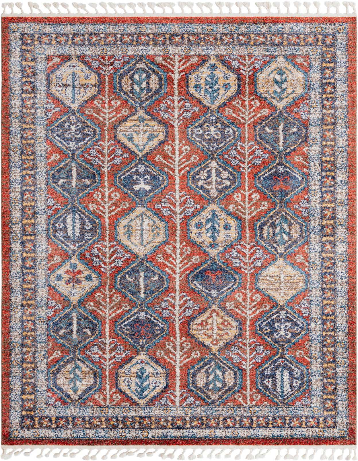 A 6x9 rectangular Aramis rug featuring a distressed stripe pattern in shades of orange, red, blue, and cream, with decorative tassels.