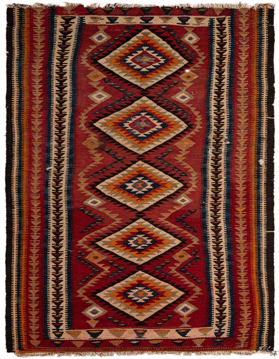 A 10 Ft Kilim Fars runner rug with a vibrant red background and a central column of large, colorful geometric diamonds in oranges, blues, and creams, flanked by striped borders.