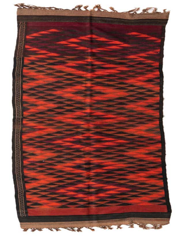 A 14 ft Kilim Fars runner rug in oranges and reds with a tribal geometric pattern, made of flatweave wool.