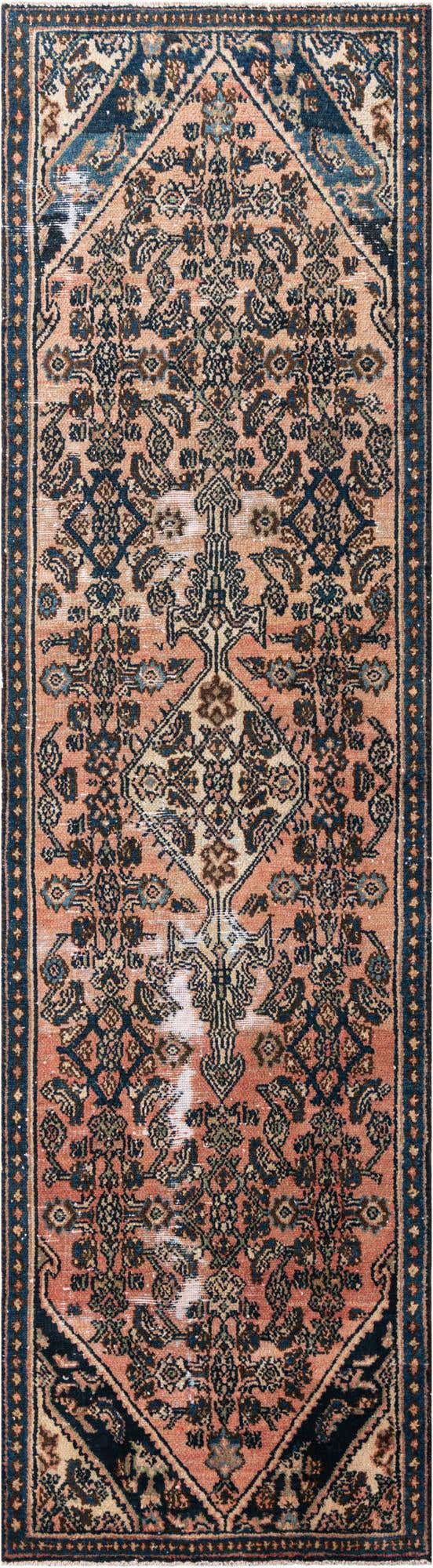 A 10 ft runner rug in a vintage Persian style, featuring a central medallion and intricate floral patterns in shades of orange, red, and navy blue.