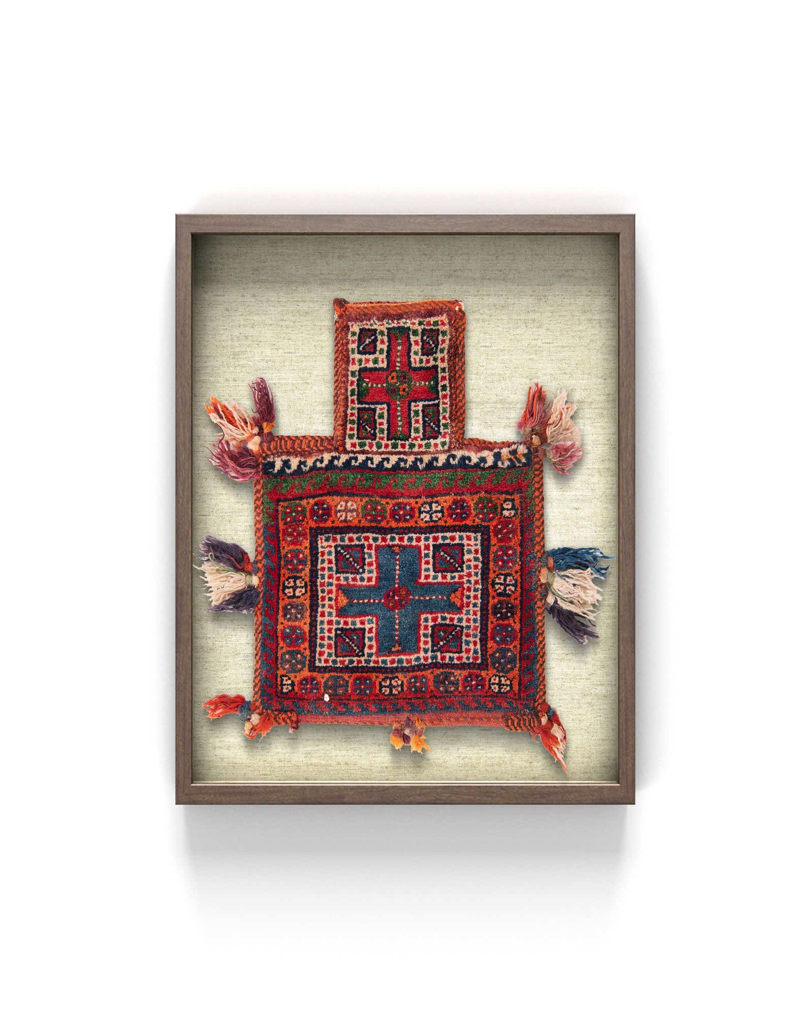 A framed square textile wall art piece featuring a traditional Oriental pattern in oranges, reds, and blues with decorative tassels.