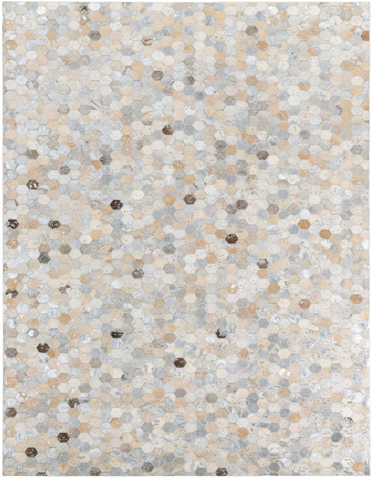 A 5x8 rectangular modern rug made from hexagonal cowhide and leather patches in varying shades of gray, silver, beige, and brown.