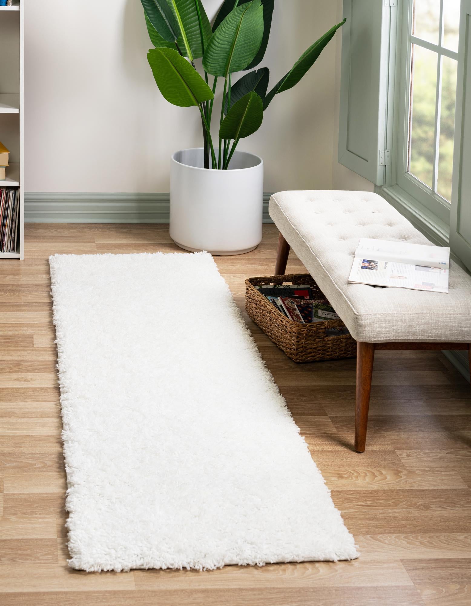 A soft, plush 7 ft white shag runner rug with a modern, solid design, perfect for a hallway.