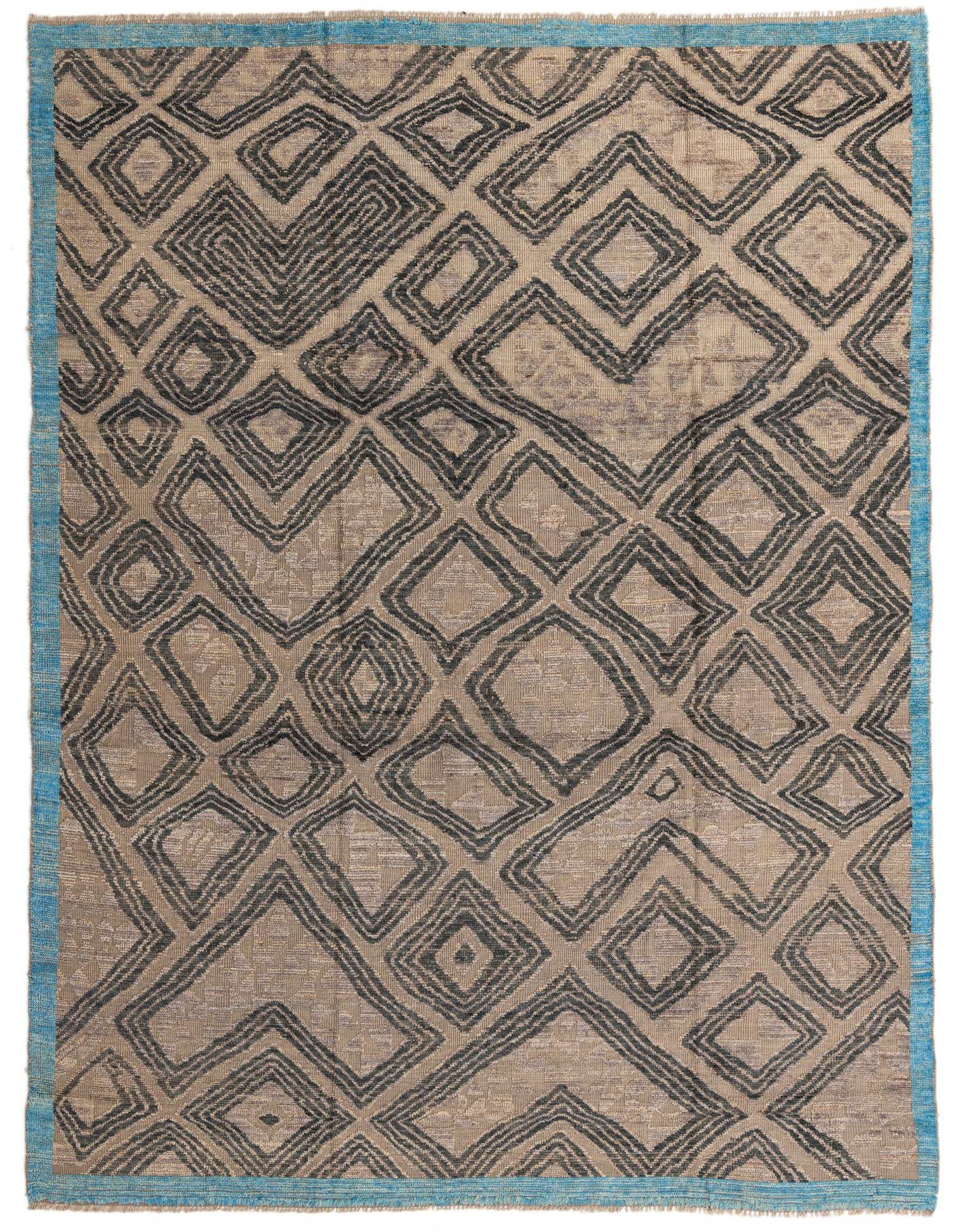 A 9x12 rectangular shag rug featuring a tribal abstract pattern of dark brown diamonds on a light brown and ivory background, with a bright blue border.