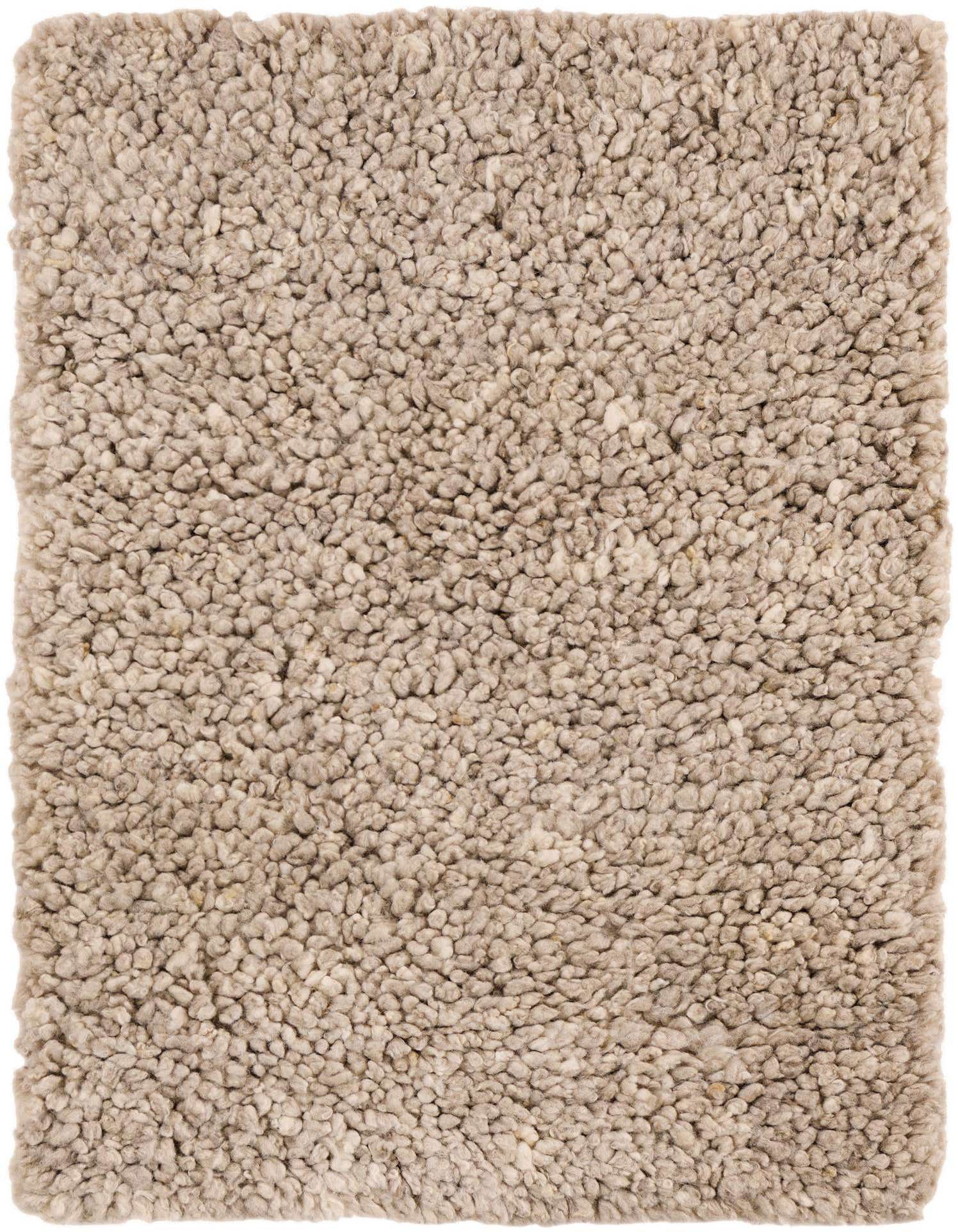 A close-up view of a 2x3 rectangular Haka Deluxe Shag rug in a blend of brown, tan, and ivory New Zealand wool, showcasing its thick, textured pile.