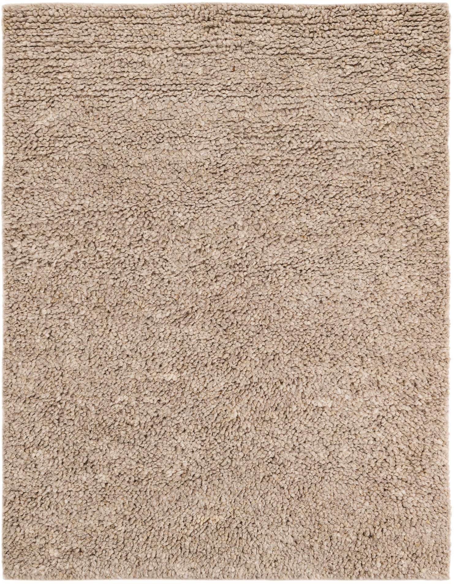 A close-up view of a 5x8 rectangular Haka Deluxe Shag rug in a warm brown and ivory blend, showcasing its thick, textured New Zealand wool pile.