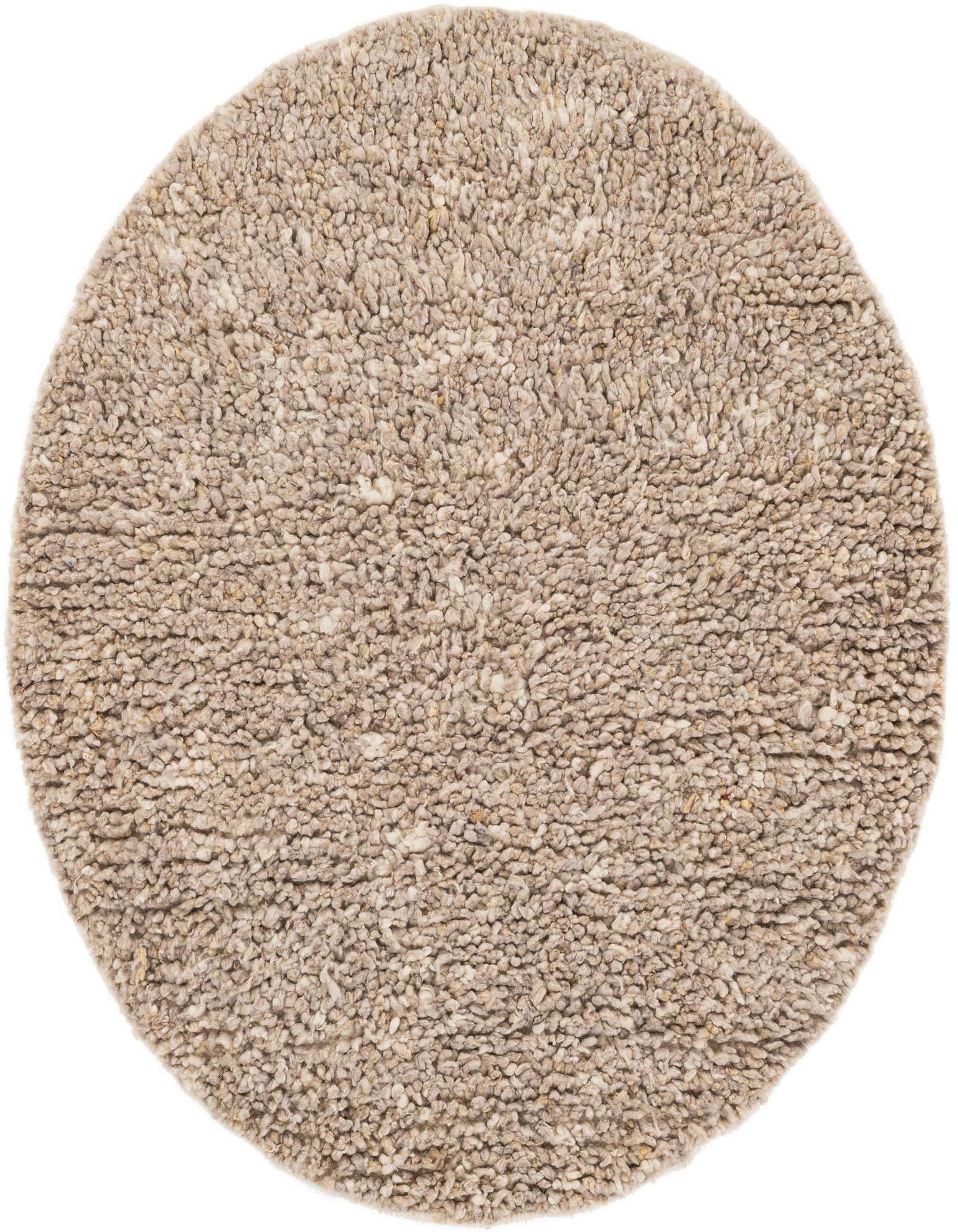 A soft, round Haka Deluxe Shag rug in varying shades of brown and cream, showcasing its plush, textured New Zealand Wool pile.