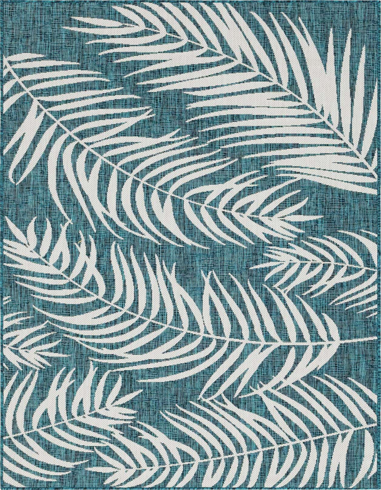 A 5x8 rectangular blue and white rug featuring a modern tropical botanical pattern of large white palm fronds on a textured teal background.