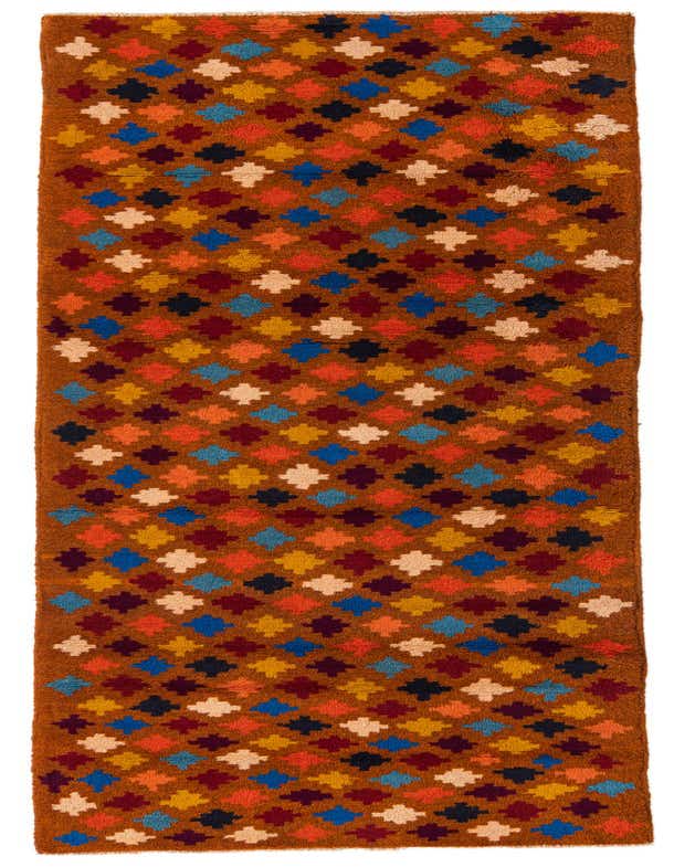 A 9 ft runner rug from the Rugs.com Balouch collection, featuring a repeating tribal diamond pattern in various shades of orange, red, blue, yellow, and cream against a warm brown background.