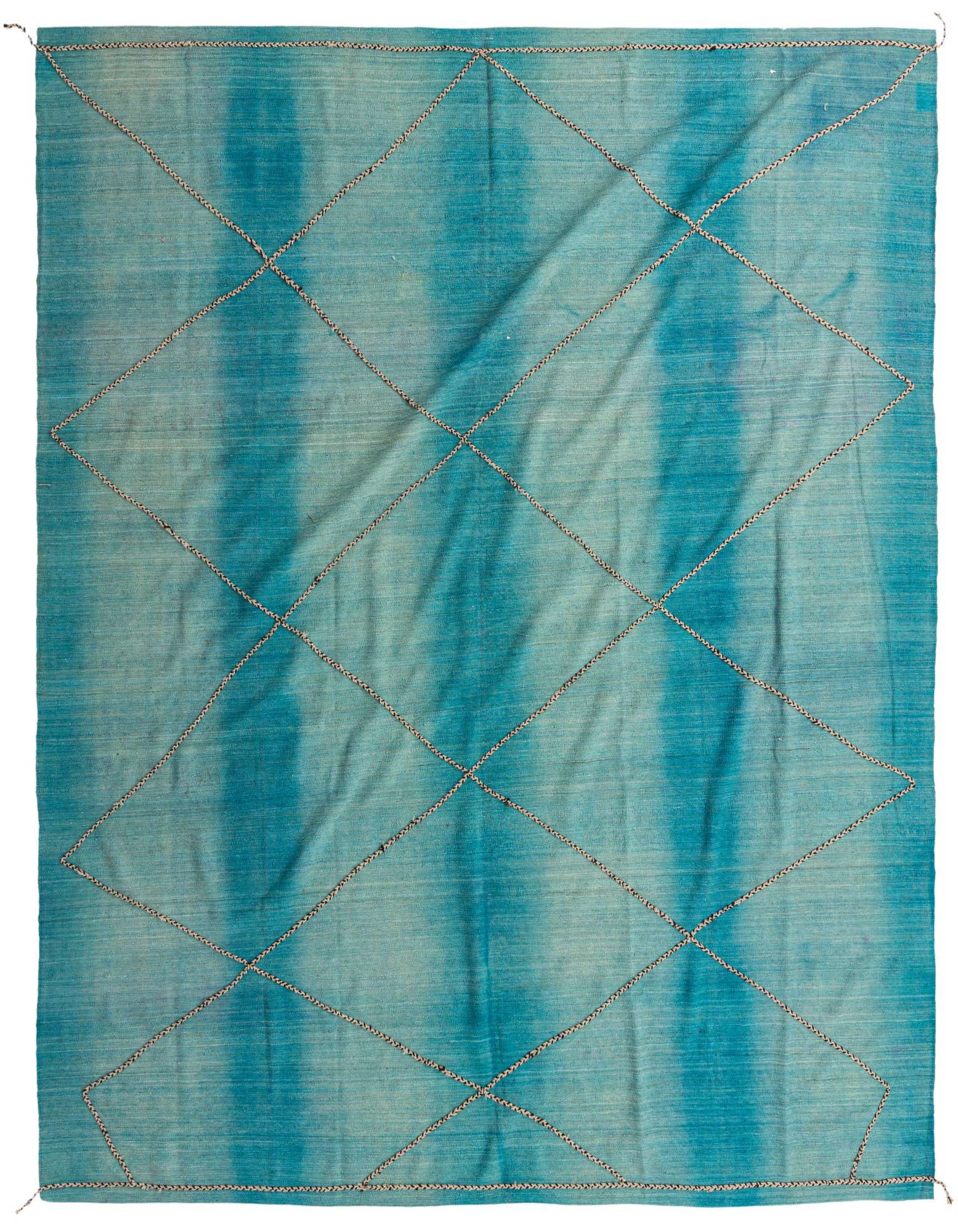 A 10x12 rectangular blue shag rug with a modern tribal diamond pattern, handmade from wool.